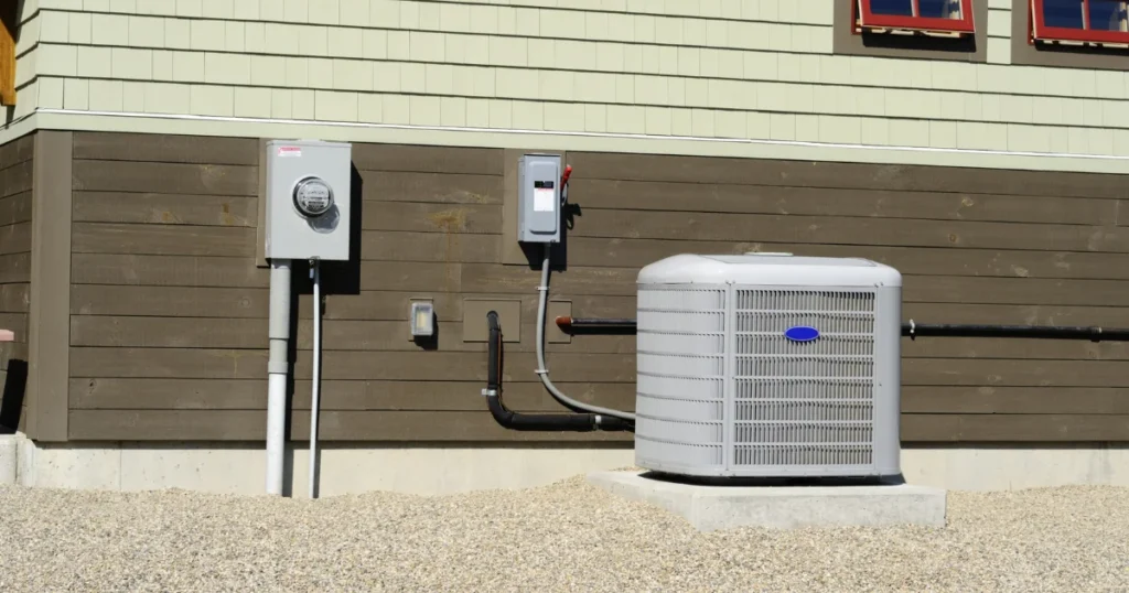 Outdoor residential HVAC condenser unit connected to an electrical disconnect and utility meter during routine HVAC maintenance.
