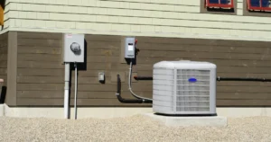 Outdoor residential HVAC condenser unit connected to an electrical disconnect and utility meter during routine HVAC maintenance.